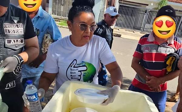Voluntária servindo refeições em marmitas durante ação nas ruas